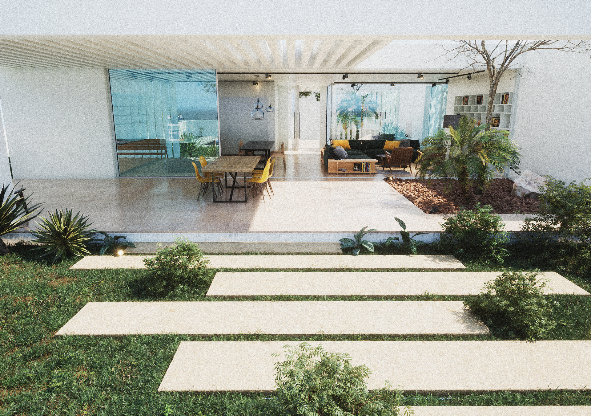 A wide-angle shot of a modern white villa featuring a large open-plan living area that flows onto a stone patio with a swimming pool and coastal vegetation.